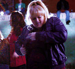 a woman in a purple jacket is standing in front of a sign that says 50 on it