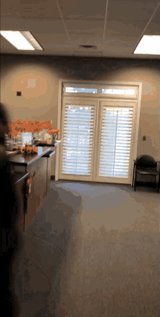 a kitchen with a sliding glass door and shutters on the windows
