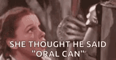a woman is looking up at a man holding a can while she thought he said `` oral can '' .