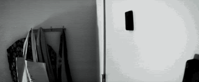 a black and white photo of a closet with clothes hanging