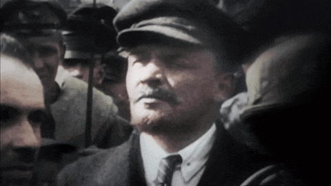 a man wearing a hat and tie stands in a crowd