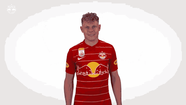 a man wearing a red shirt with a red bull on the front