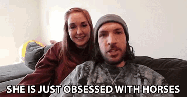 a man and a woman are sitting on a couch with the words `` she is just obsessed with horses '' behind them .