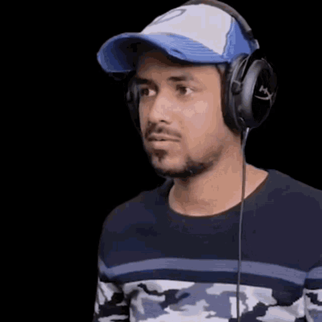 a man wearing headphones and a hat is making a face .