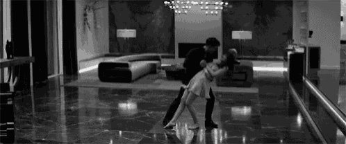a man and a woman are dancing in a living room .