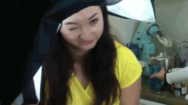 a woman in a yellow shirt is making a face