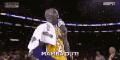 a basketball player is standing in front of a microphone with a towel around his shoulder .