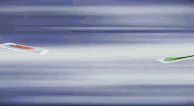 two toothbrushes are flying in the air against a blue background .