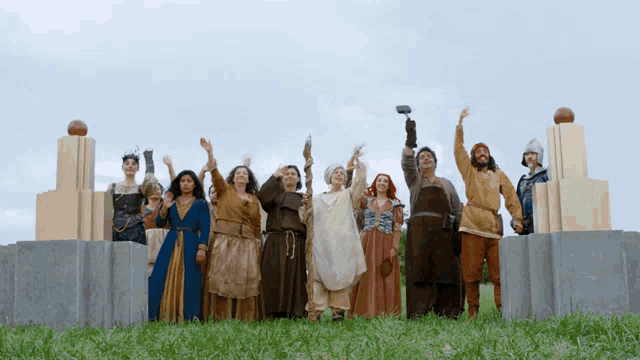 a group of people in medieval costumes are standing in a field