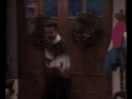 a blurry picture of a person standing in front of a door with a wreath on it
