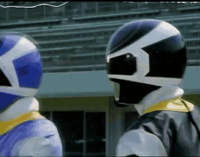 two power rangers are standing next to each other in front of a stadium