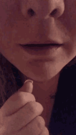 a close up of a person 's face with their mouth open and a cigarette in their mouth .