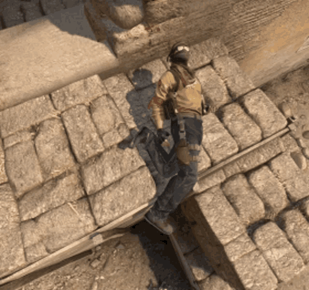 a man standing on a set of bricks with a gun in his hand