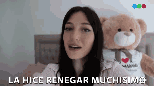 a woman is sitting on a bed next to a teddy bear and says la hice renegar muchismo