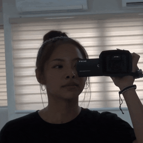 a woman taking a picture with a camera that says sony on it
