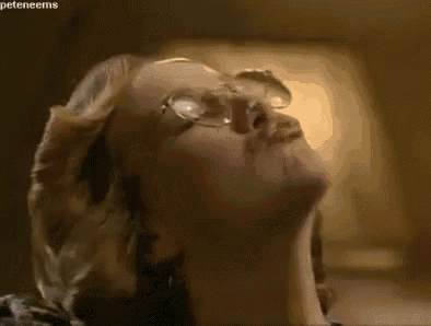 a close up of a woman wearing glasses and making a funny face .