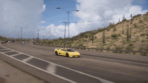 a yellow sports car is driving down a desert road