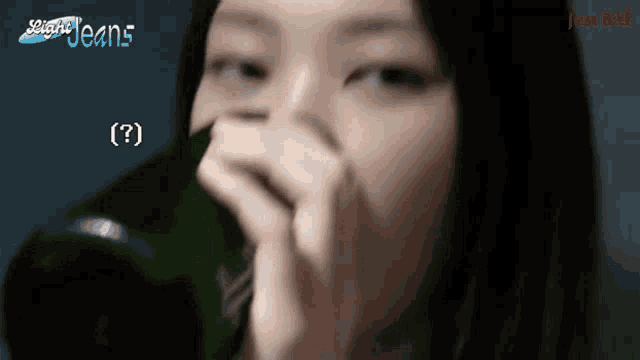 a woman drinking from a green bottle with the word jeans on the bottom right