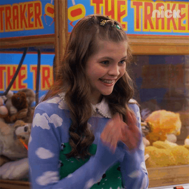 a girl is clapping in front of a sign that says the trakes on it