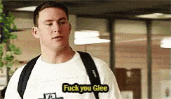 a man wearing a white t-shirt that says `` fuck you glee '' .