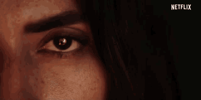 a close up of a woman 's eye with a netflix logo behind her