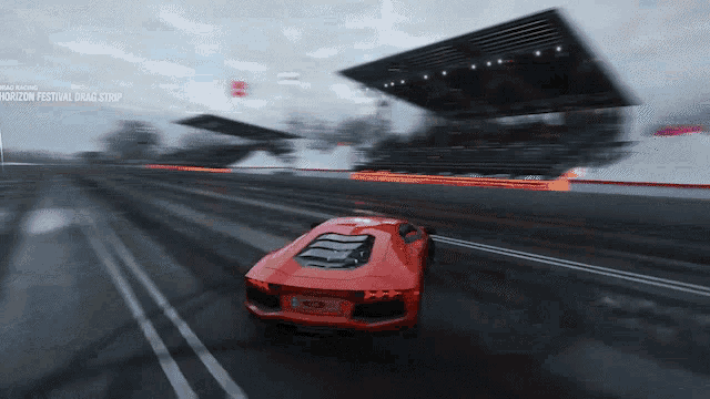 a red sports car is driving down a drag strip in a video game
