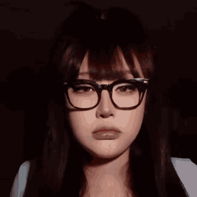a woman wearing glasses is sticking out her red tongue
