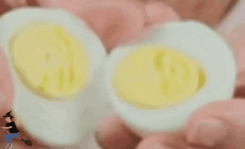 a person is holding two hard boiled eggs .
