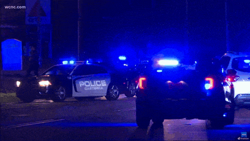 a police car is parked on the side of the road at night