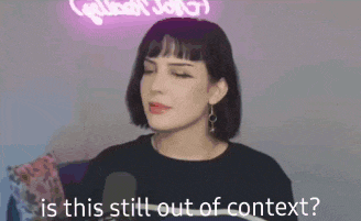 a woman is sitting in front of a microphone and asking is this still out of context .