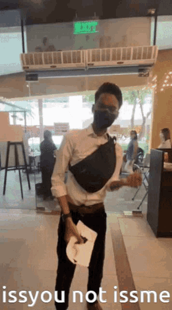a man wearing a mask is standing in front of a glass door with the words issyou not issme below him