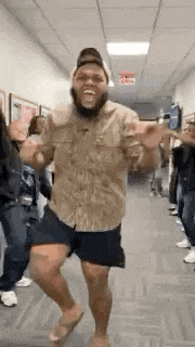 a man is dancing in a hallway with a crowd of people .