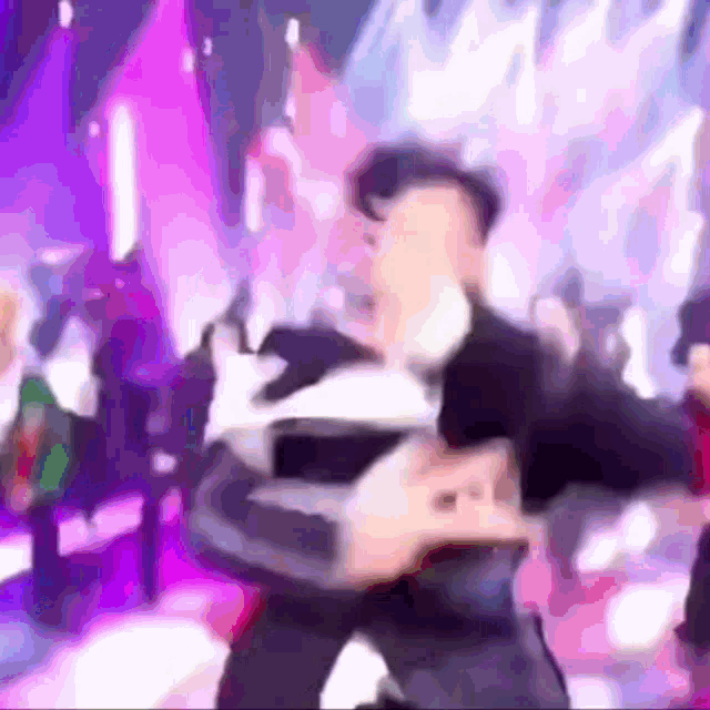 a blurry picture of a man in a suit and hat dancing on a stage