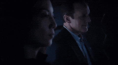 a man and a woman are standing next to each other in the dark .