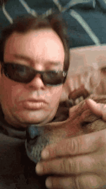 a man wearing sunglasses is holding a can of soda