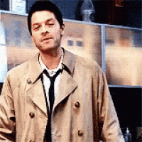 the man is wearing a trench coat and tie .