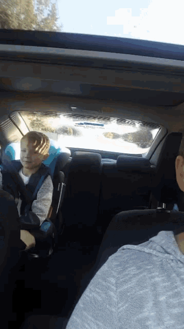 a child in a car seat looks out the window
