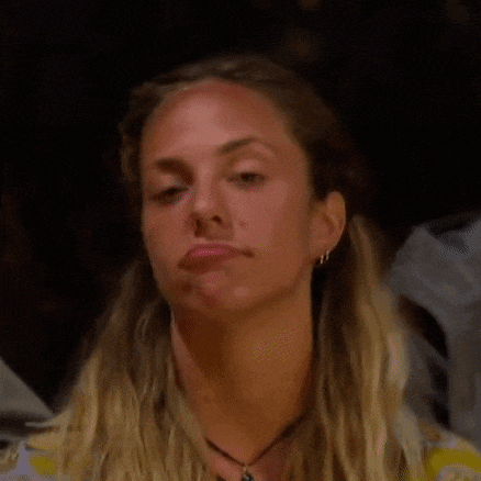 a woman is making a funny face with her mouth open and a necklace around her neck .