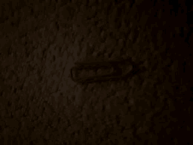 a red paper clip is sitting on a dark surface