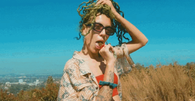 a pixel art of a woman with dreadlocks and sunglasses