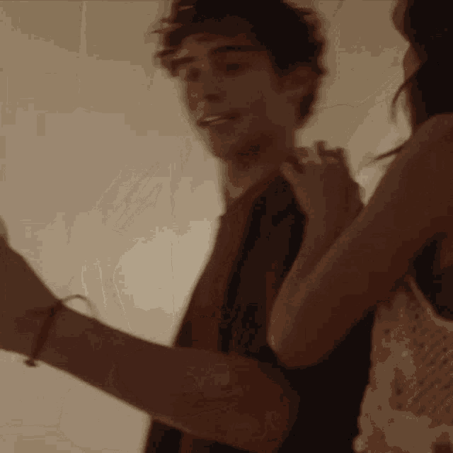 a man and a woman are dancing together and the woman is holding the man 's arm .