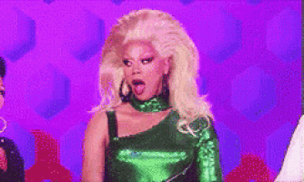 a drag queen is wearing a green dress and making a surprised face .
