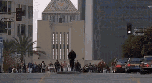 a crowd of people are walking down a street in front of a building .