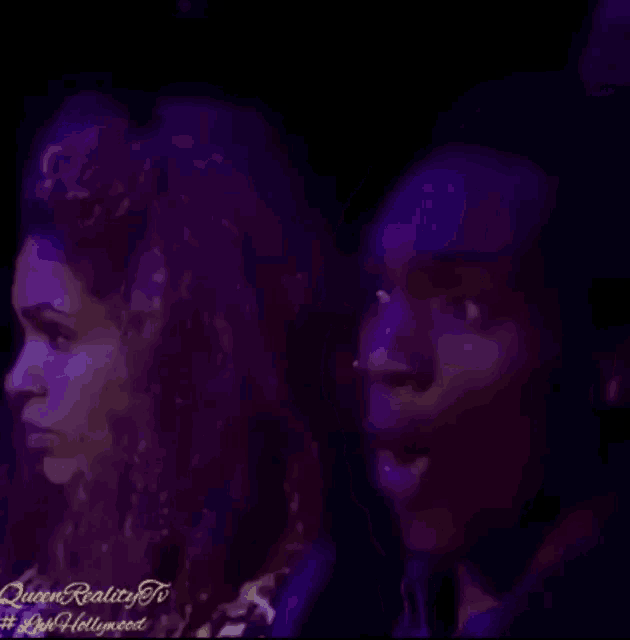 a man and woman are standing next to each other in a dark room .
