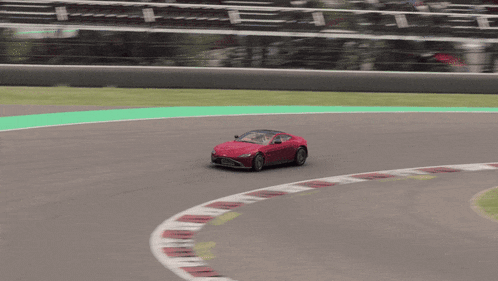 a red car is driving around a curve on a track