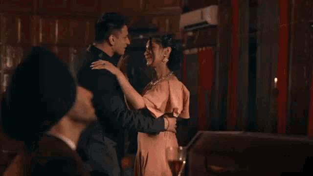 a man and a woman are dancing together in a dark room .
