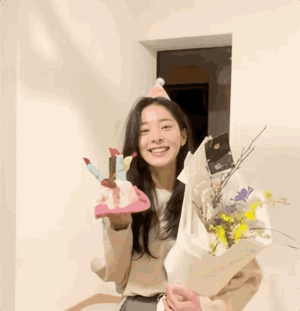 a woman is holding a bouquet of flowers and a birthday hat