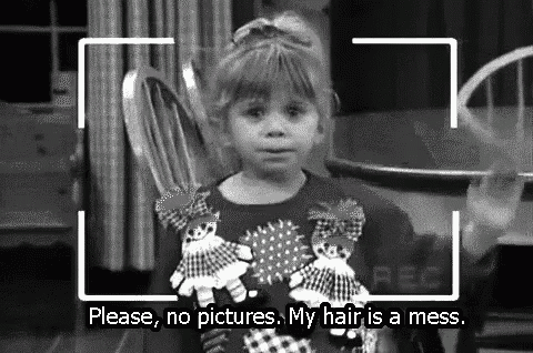 a little girl is sitting in a chair holding a stuffed animal and a doll .