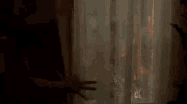 a man is standing in front of a window with a fire behind the curtains .