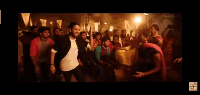 a man in a white shirt is dancing in front of a crowd of people